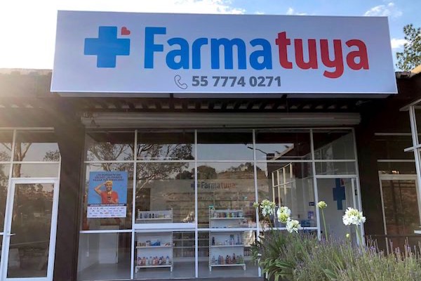Fachada moderna con cristal de una sucursal Farmatuya Integral