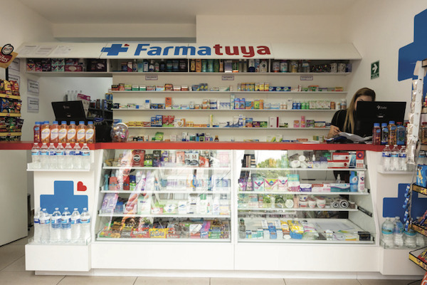 Interior del mostrador de una sucursal Farmatuya Súper con empleada atendiendo
